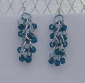 Anodized aluminum rings and glass beads colors: bright silver, sky, and matte teal beads beads weave: shaggy loops size: 1  5/8