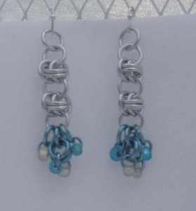 Anodized aluminum rings and glass beads colors: bright silver and sky, white and teal beads weave: barrel size: 1  3/4